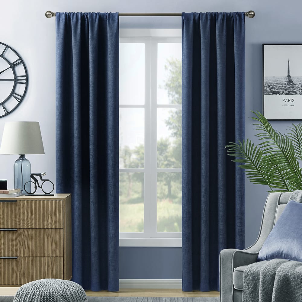 Navy Hayden blackout curtains in a calm room with a lamp and a side table
