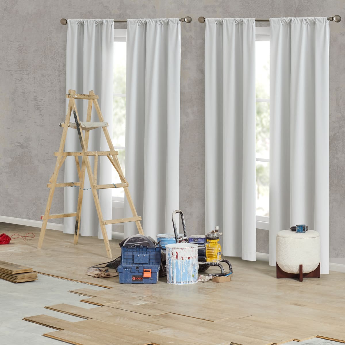 Four white Contractor Set panels on rods across two windows in a room under renovation: a wooden ladder, paint tins and a toolbox on a half-laid wood floor