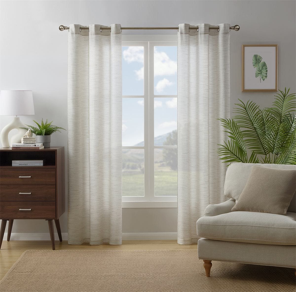 Dover light filtering panels in natural on grommets at a window, a dresser and an armchair