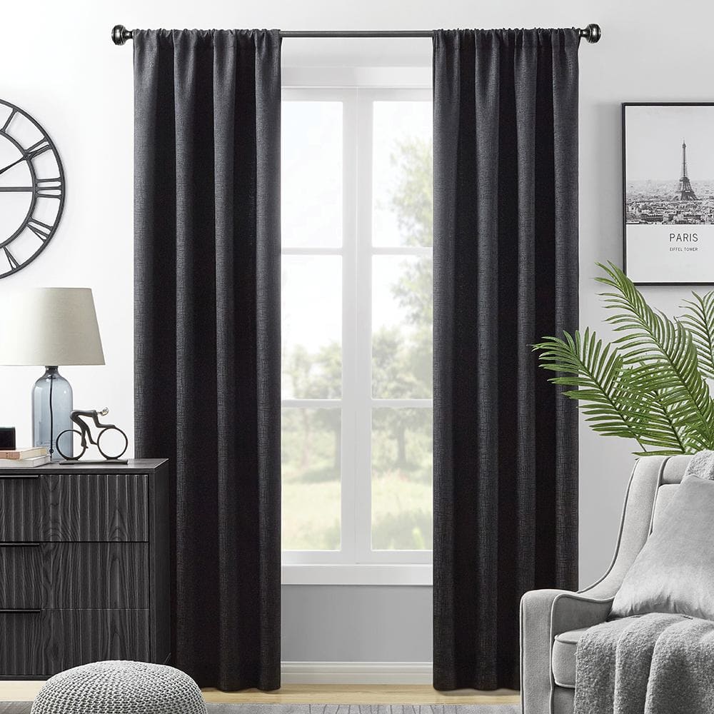 Hayden blackout panels in black on a rod at a window, a wood dresser and an armchair