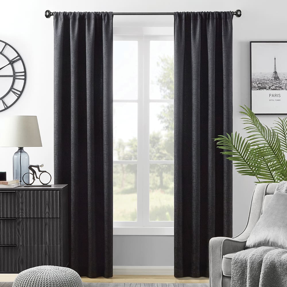 Black Hayden blackout curtains at a window, a wood dresser and an armchair