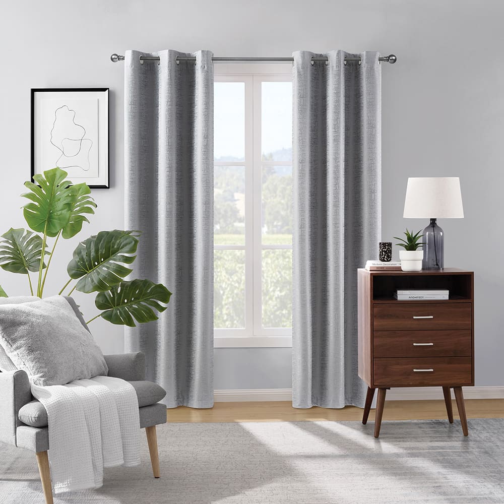 Grey Paloma 100% blackout curtains at a window in a furnished room
