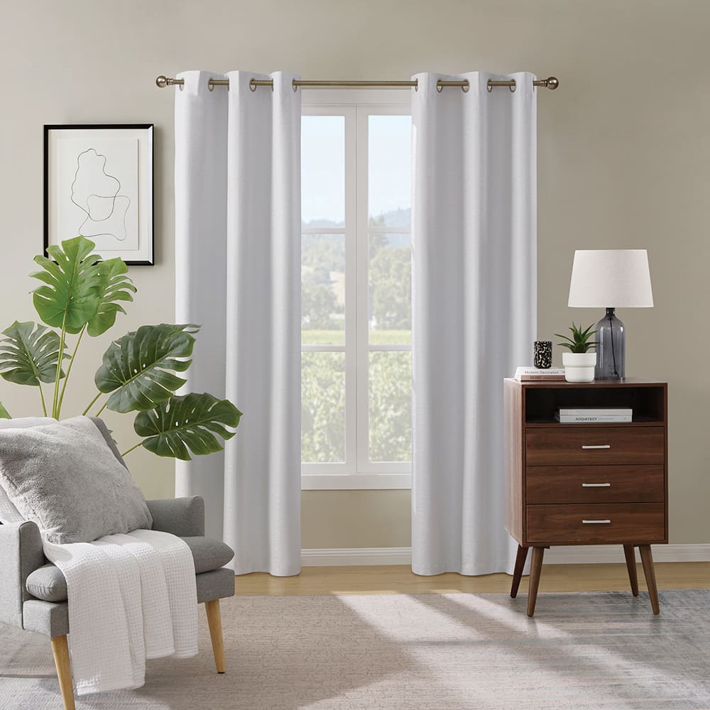 Paloma 100% blackout curtains in white at a window in a furnished room