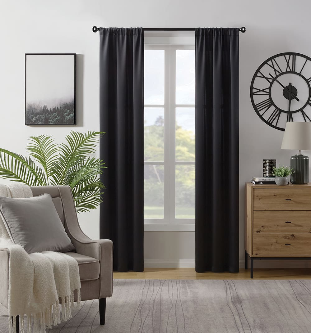 Savoy room darkening curtains in black at a window in a furnished room