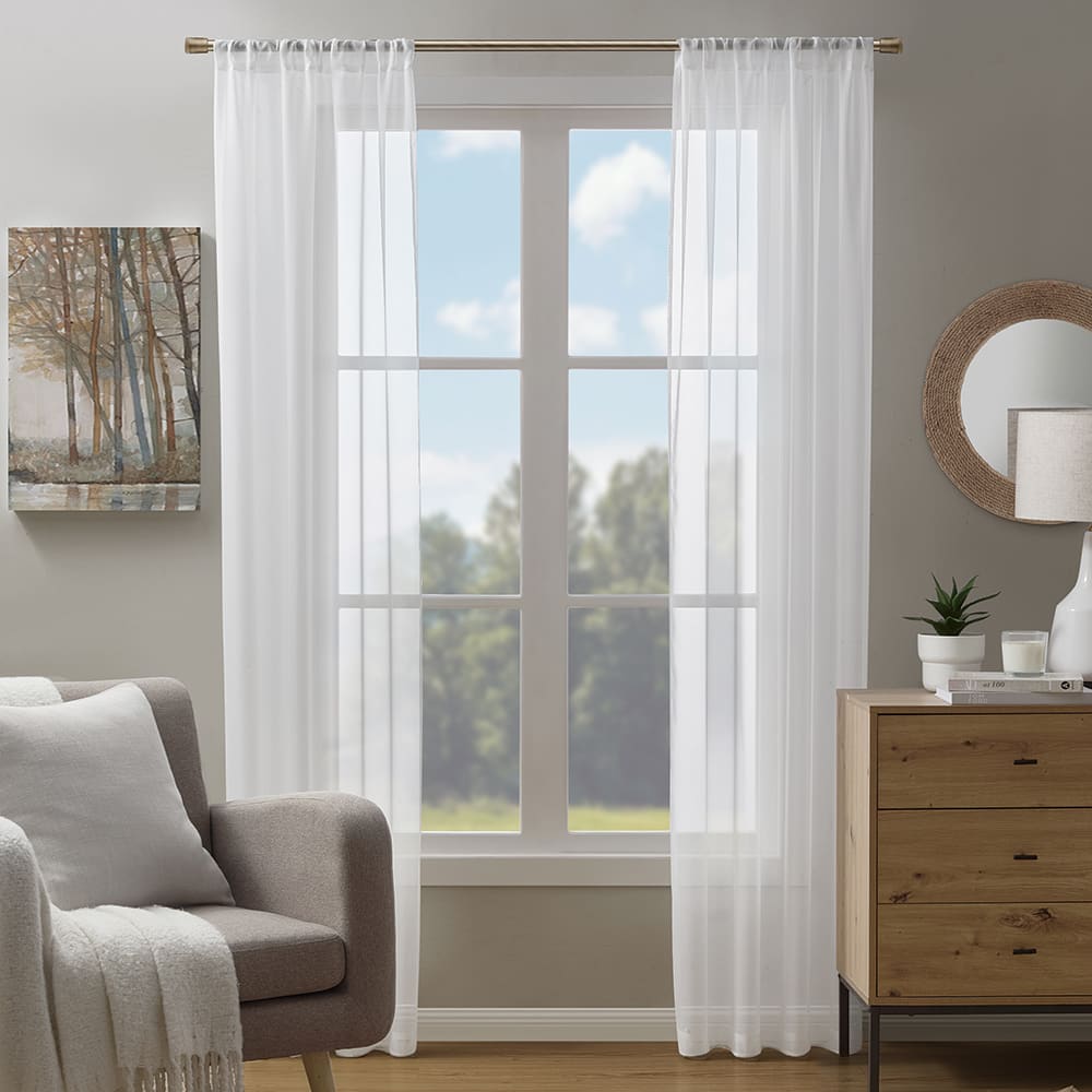 Voile sheer curtains in white at a window in a furnished room